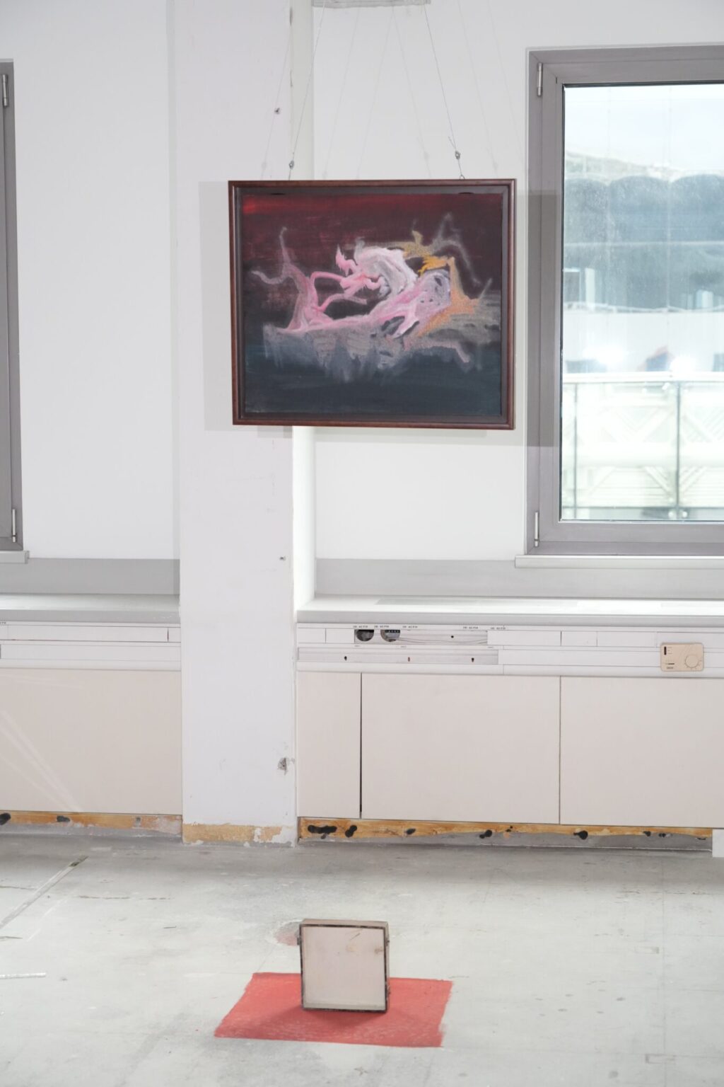 Abstrakcyjny obraz w ciemnych barwach ukazujący różowe sylwetki ludzkie w nietypowych pozach.