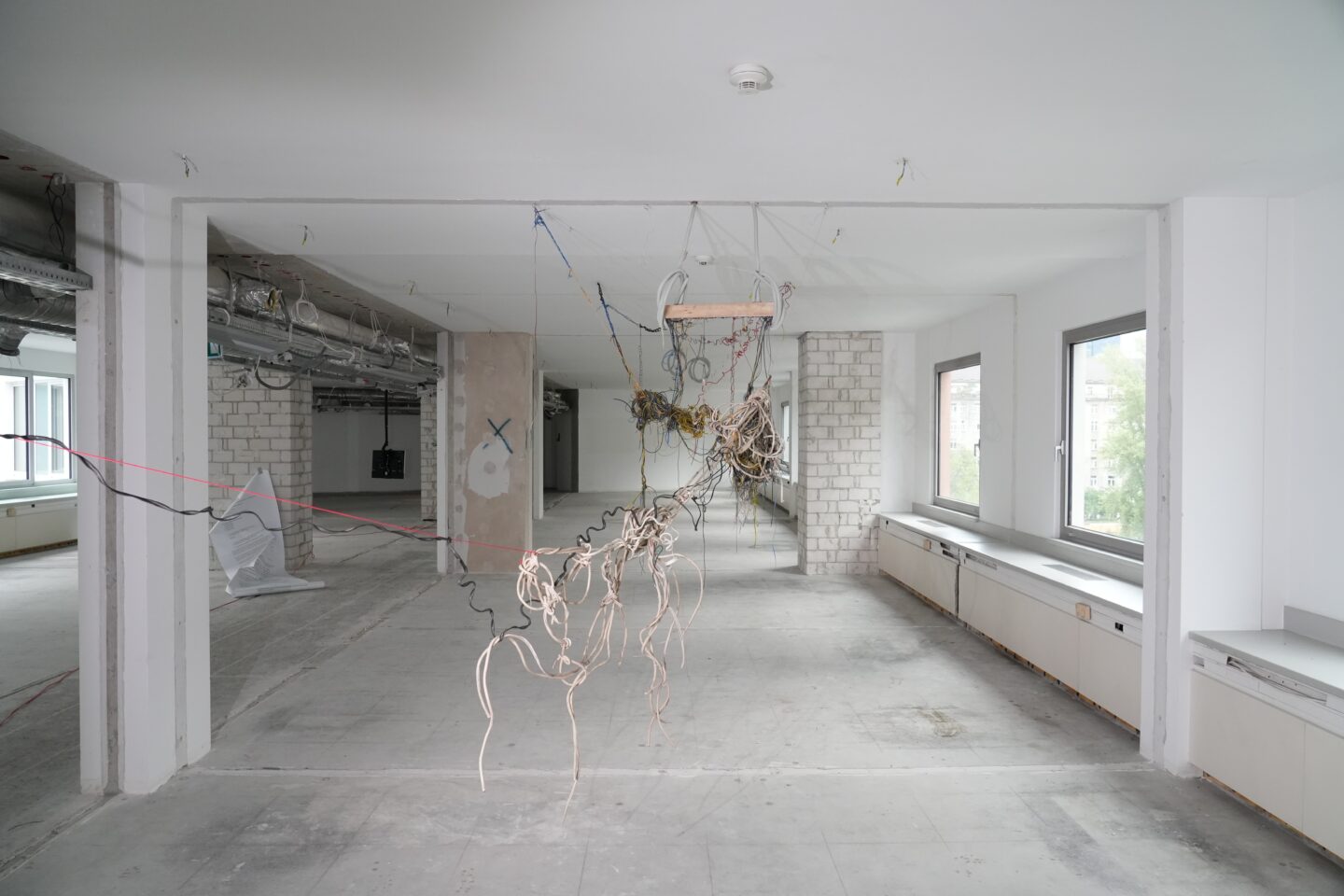 Wirtuozerska instalacja wykonana w głównej mierze z kabli, podwieszona od sufitu.