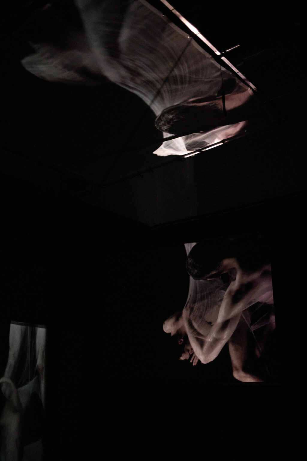 Wideo instalacja przestrzenna przestawiająca intymne relacje między dwojgiem mężczyzn. Projekcja na trzech transparentnych ekranach