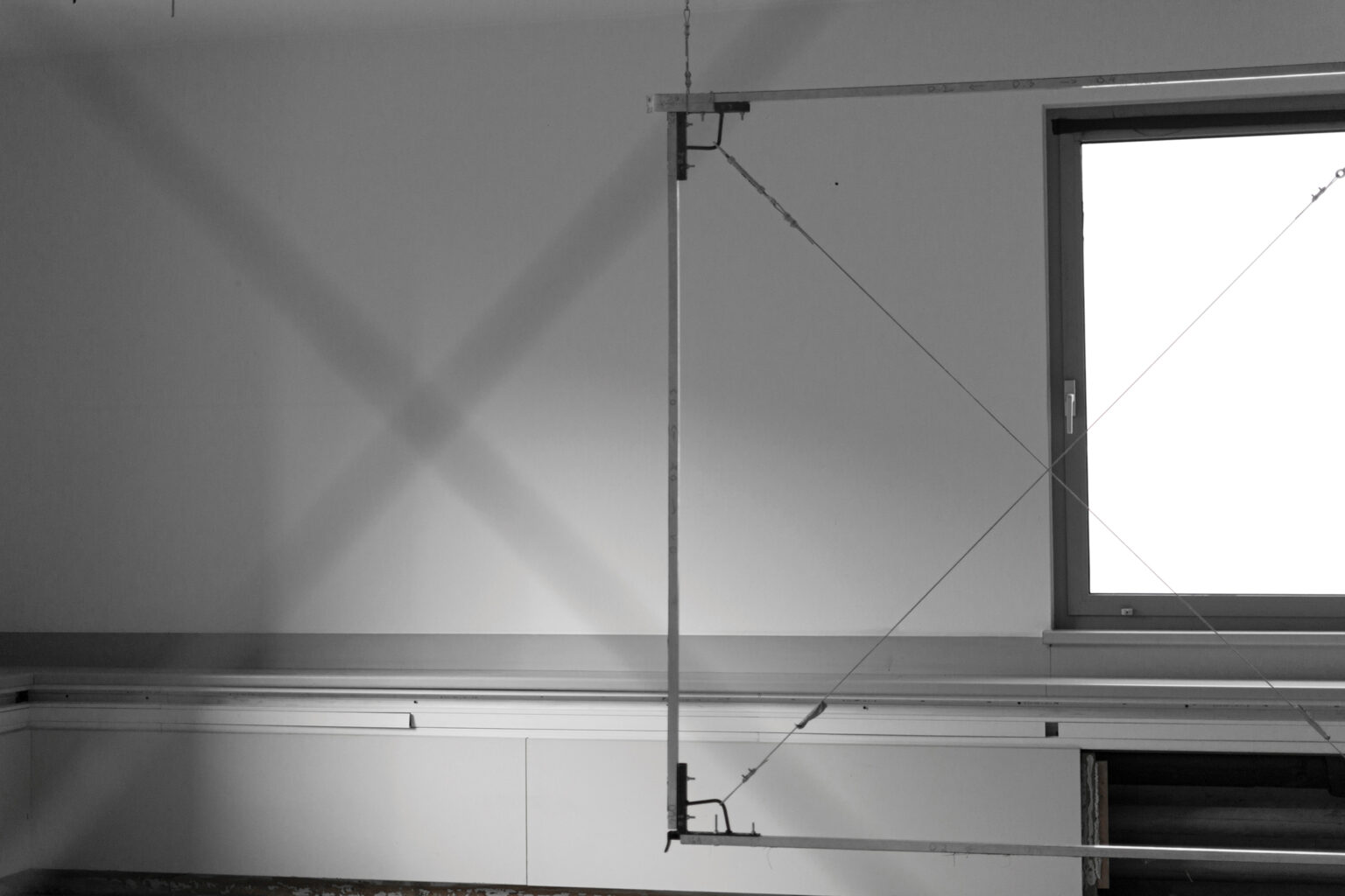 Metalowe obiekty przestrzenne eksponowane w Hop Gallery. Obszar z zaaranżowaną scenografią VR - metalowe, płaszczyzny w formie ram, które nakreślają przestrzeń sześcianu, a w rogach stoliki z okularami do VR.