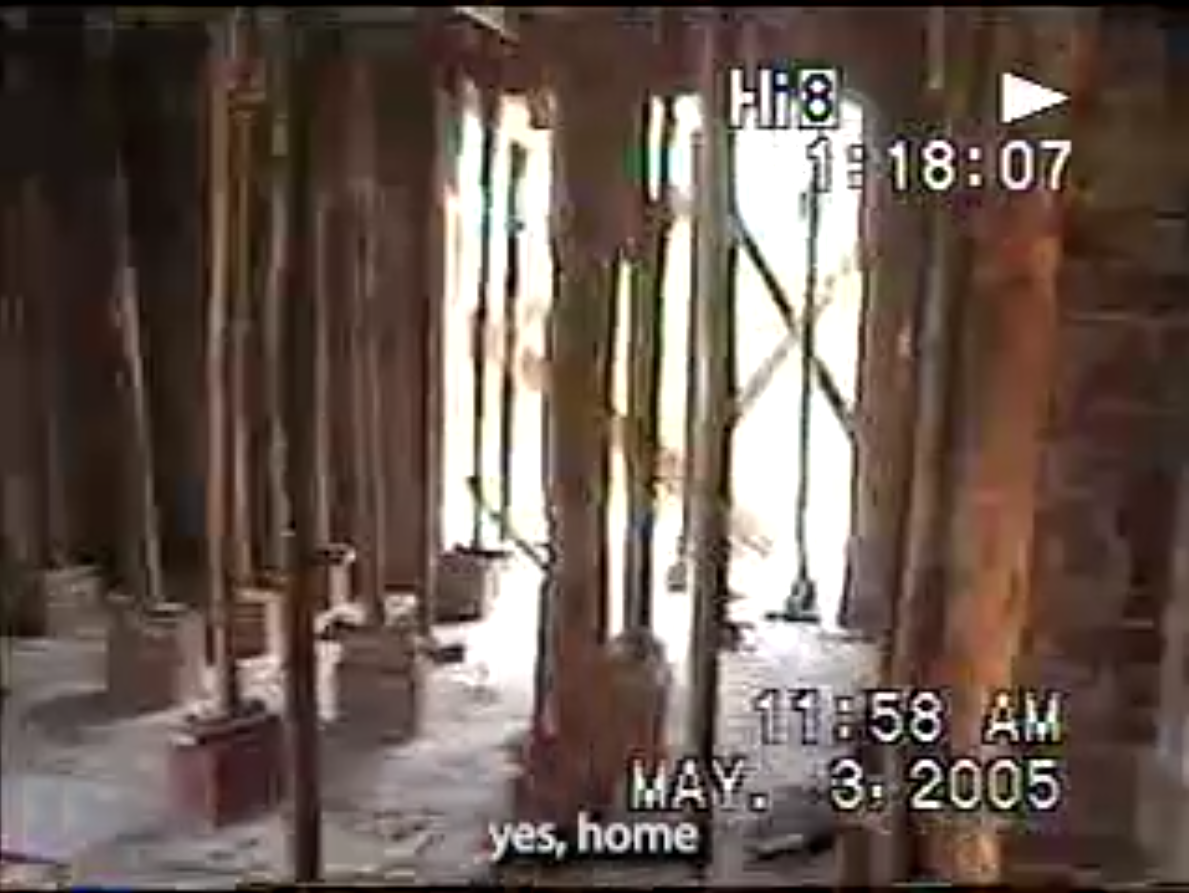 Kadr wideo. Budowa domu. Widoczne drewniane rusztowanie rozpostarte pomiędzy sufitem a podłogą.