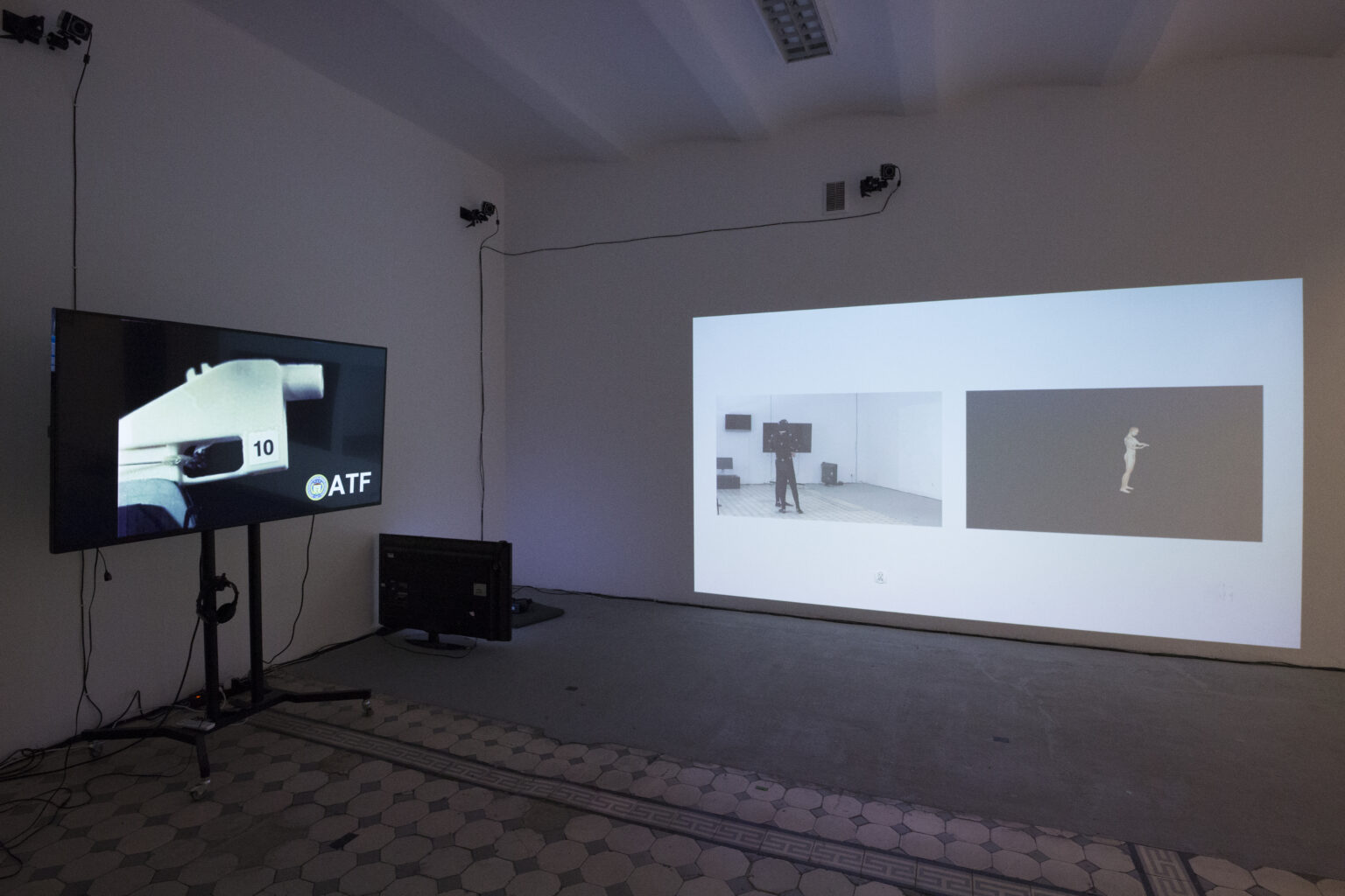 widok wystawy końcoworocznej, telewizor i duża projekcja na ścianie.