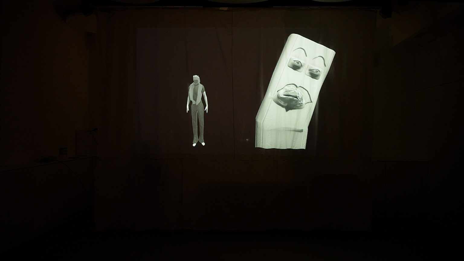 projekcja na prześcieradle, monochromatyczna scena 3D, dwie postaci, jedna bardziej realistyczna, druga wyglądająca jak maska z kartonu